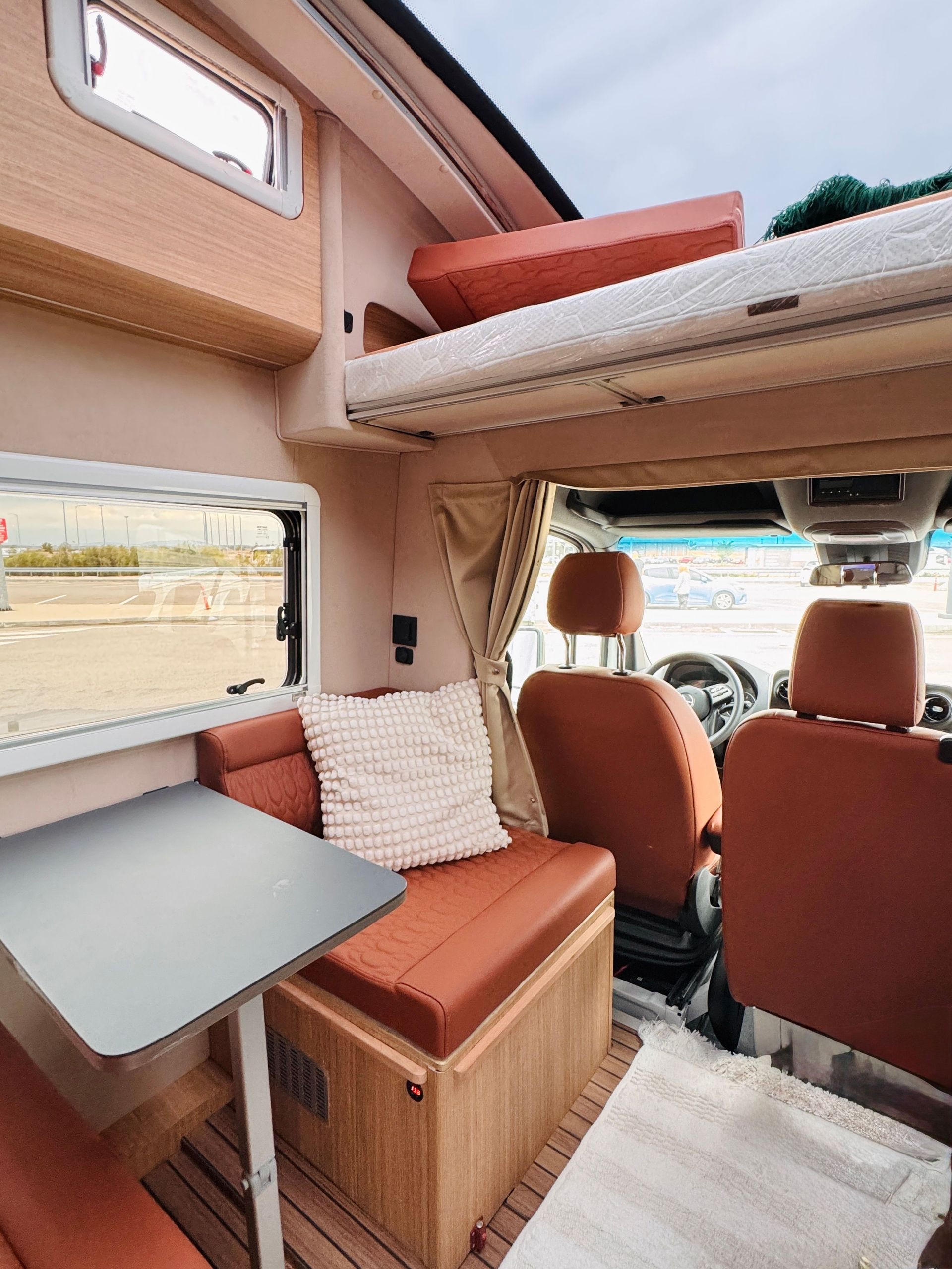 Spacious modern campervan interior with comfy seating and practical design for travel adventures.